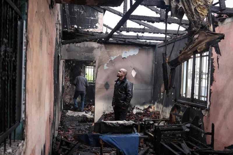 A Palestinian man inspects the remains of his burnt-out family home following a reported attack by Israeli settlers in the village of Fandaqumiya, south-west of Jenin, in the Israeli-occupied West Bank.