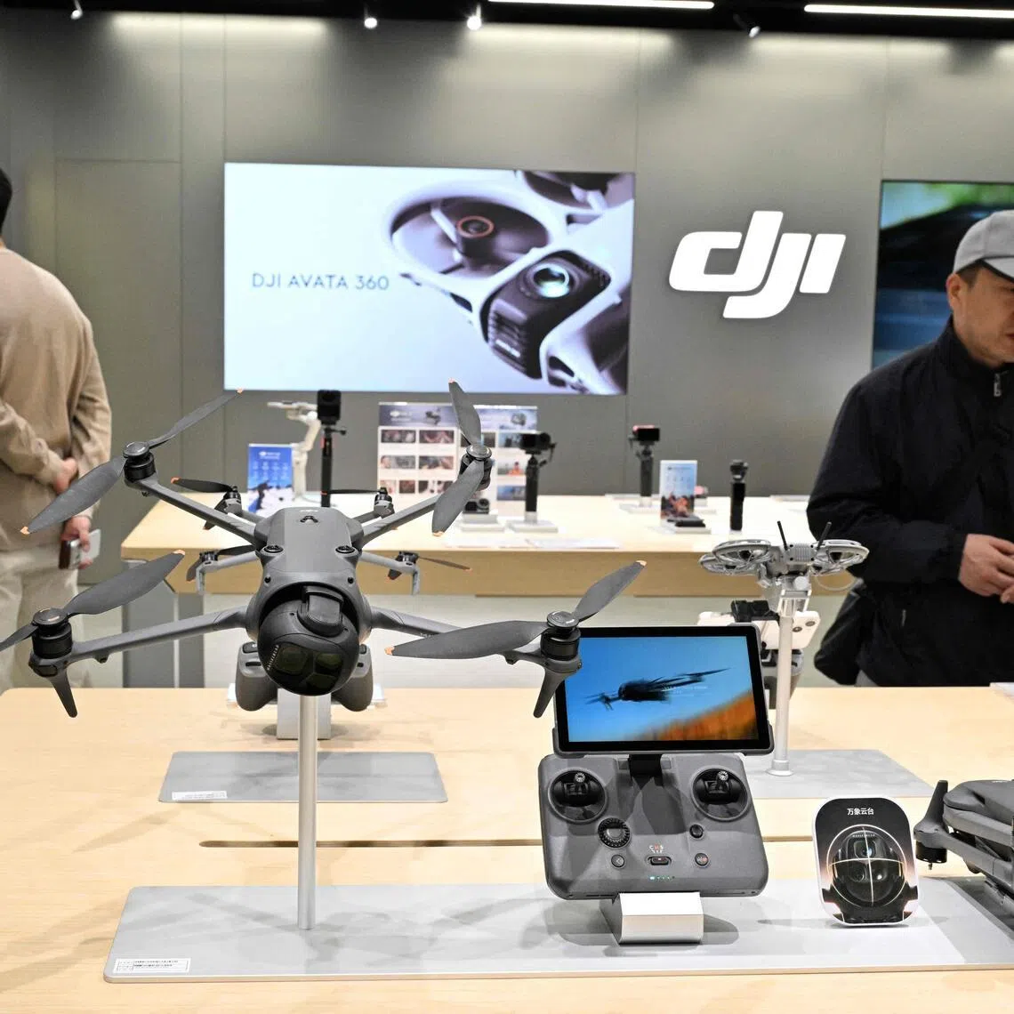People visit a DJI store by company manufacturer DJI at a mall in Beijing on April 28, 2026. On May 1, the Chinese government will ban new consumer drone sales.