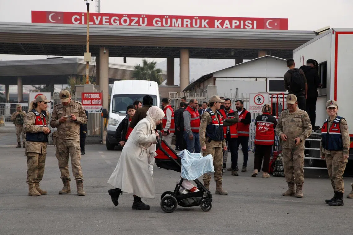 FILE PHOTO: Dua, a Syrian migrant woman with her baby, arrives at Cilvegozu border gate to cross into Syria, after Syrian rebels ousted President Bashar al-Assad, in Hatay province, Turkey, December 11, 2024. REUTERS/Dilara Senkaya/File photo