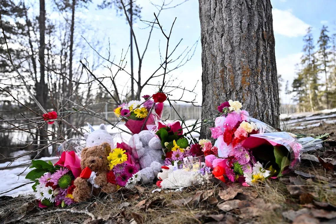Flowers and toys lie on the ground near the site of a mass shooting at a high school, in the town of Tumbler Ridge, British Columbia, Canada on Feb 11.