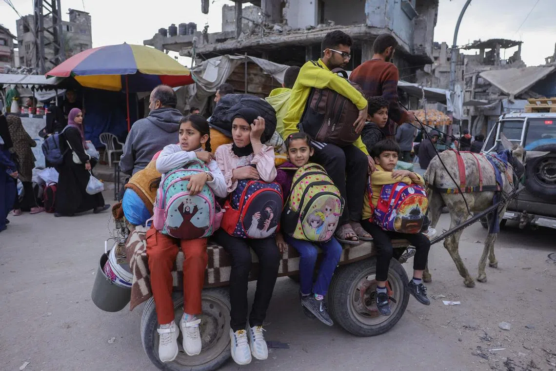 Palestinians ferry their belongings as they flee following Israeli evacuation orders.