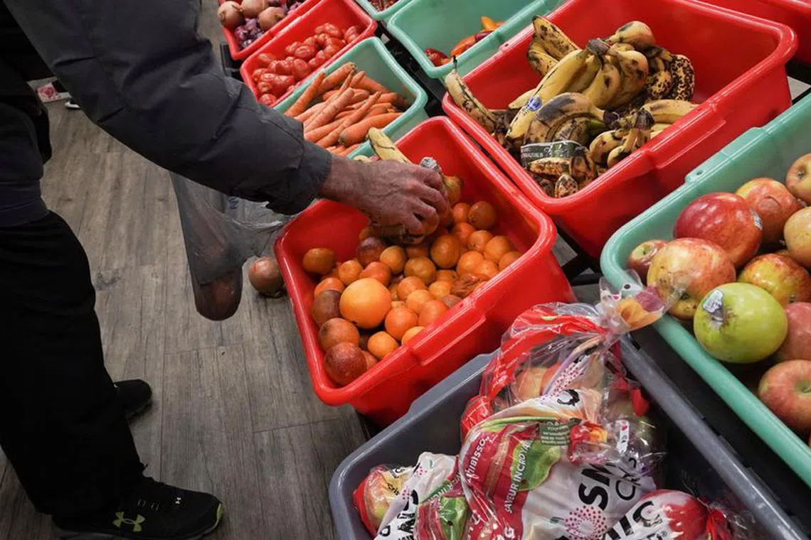 A community member grabs a piece of fruit at The Community Assistance Center food pantry, in Atlanta, Georgia, U.S. April 12, 2023.  REUTERS/Megan Varner