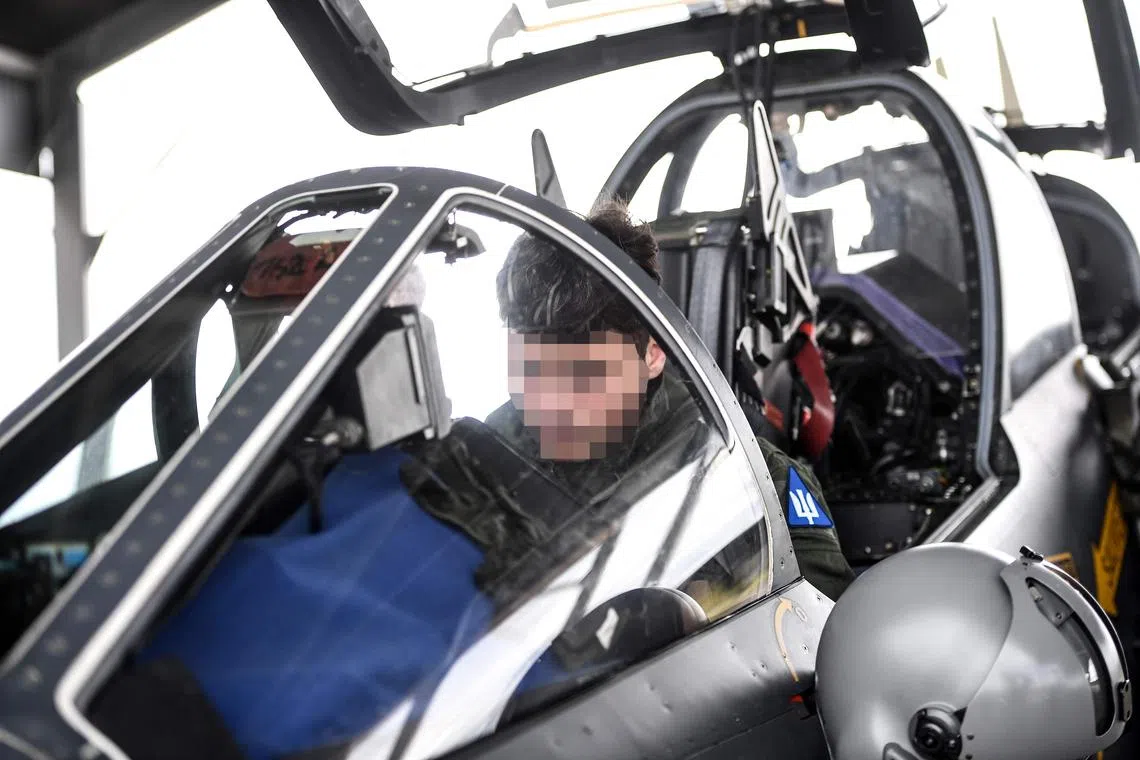 An Ukrainian trainee gets ready ahead of a flight with an unseen French military instructor onboard an Alpha Jet fighter jet.