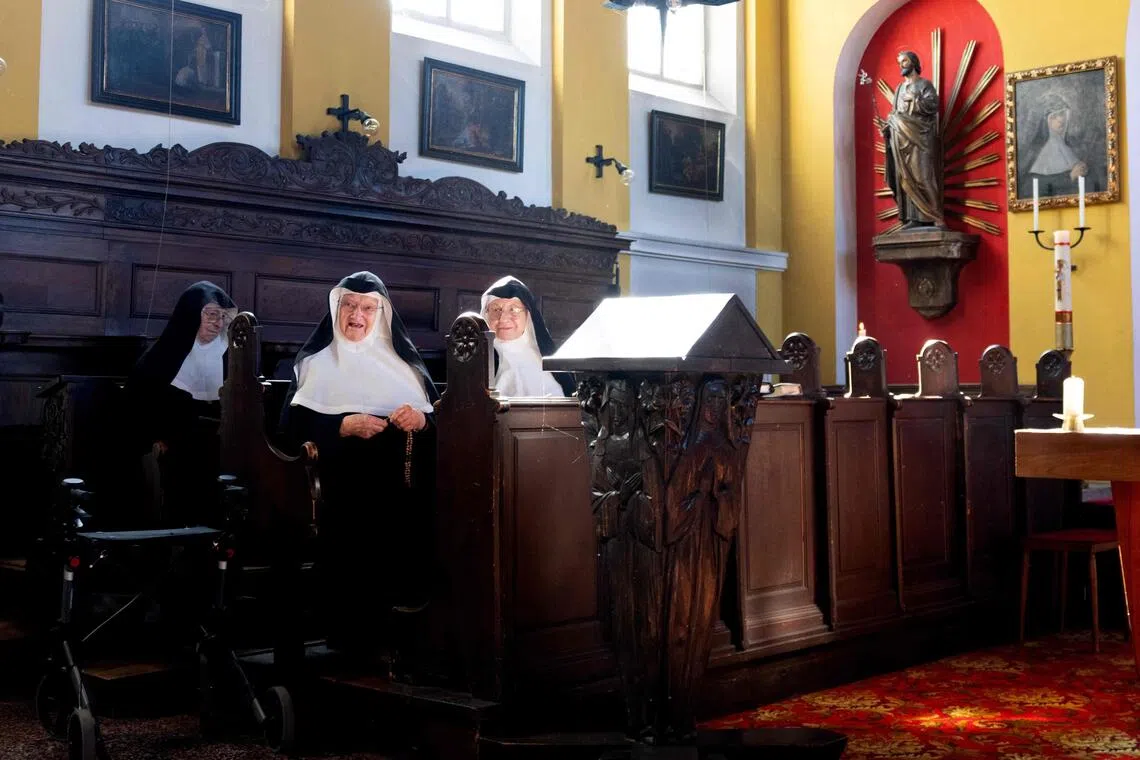 Sisters Rita (R), 81, Regina (L), 86, and Bernadette (C), 88, celebrate a mass with over a dozen of supporters and former students, at the convent chapel of the Goldenstein castle, in the municipality of Elsbethen, south of Salzburg city, Austria on September 20, 2025. Supporters of three rebel nuns in their 80s who had graced international headlines after fleeing their care home to occupy their former convent in Austria's Salzburg province flocked to the nunnery Saturday in a show of solidarity. (Photo by Joe Klamar / AFP)