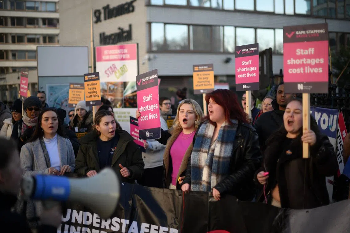 Healthcare workers hold placards at a picket line outside St Thomas' Hospital in London on Feb 6, 2023.