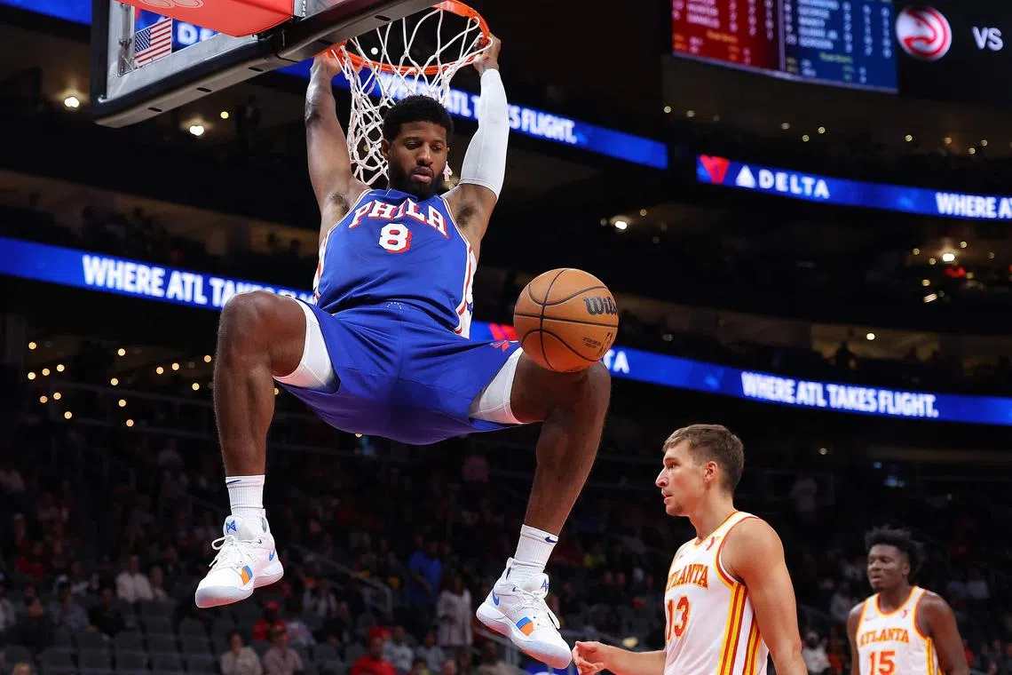 Paul George of the Philadelphia 76ers dunking against the Atlanta Hawks during the first quarter of a pre-season game at State Farm Arena on Oct 14. He was injured during the second quarter of his team's 104-89 win.