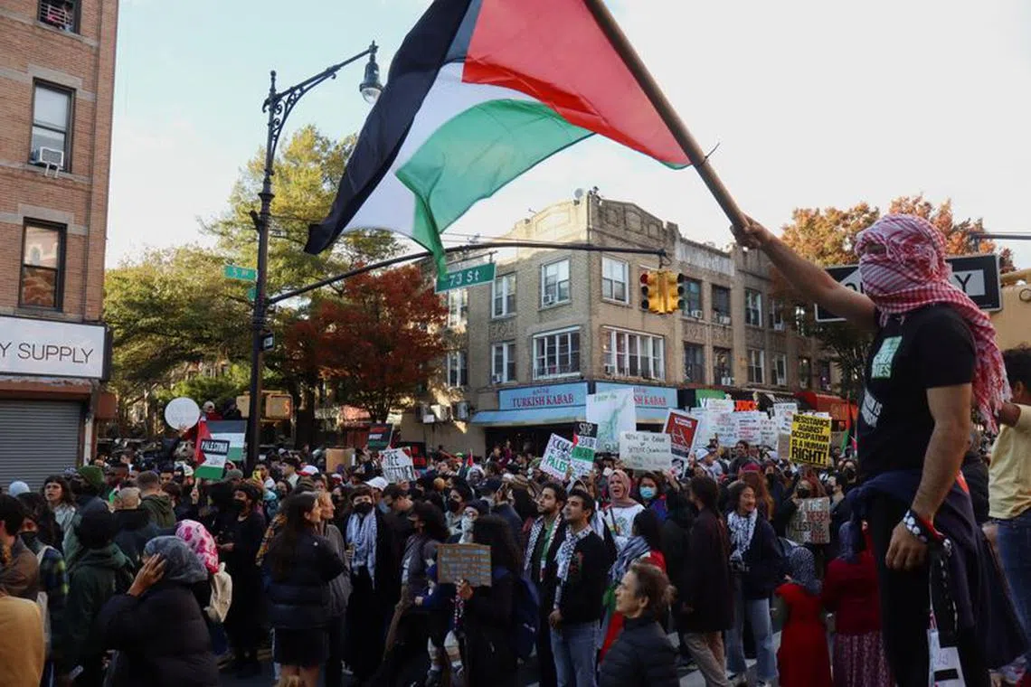 A man waves a Palestinian flag during a protest to call for a ceasefire and an end to the violence in Gaza in Bay Ridge, Brooklyn, New York, U.S., October 21, 2023. REUTERS/Aurora Ellis