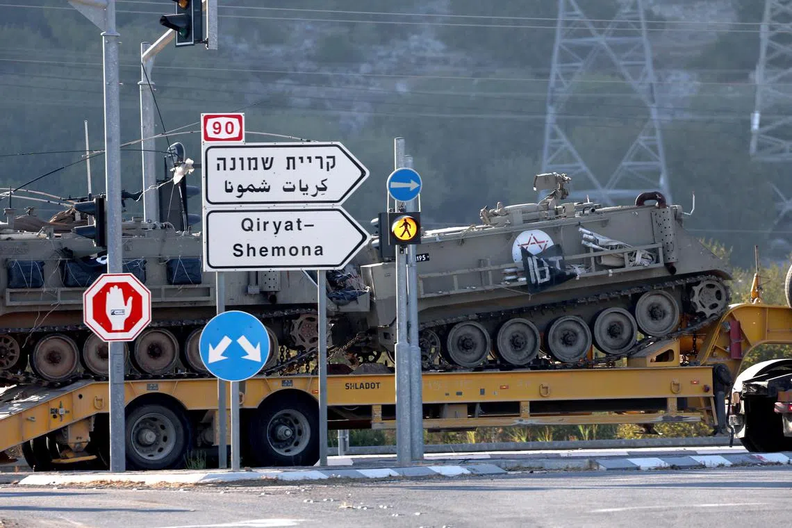 A truck carrying Armoured Personnel Carriers moves toward Israel's northern border with Lebanon on Sept 26, 2024. 