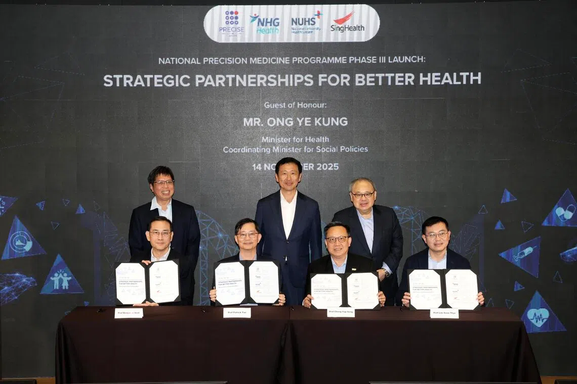 CMG20251114-TayYM02/郑一鸣 /卢慧菁，郭跃男 /National Precision Medicine
Programme Phase Ill Launch:
Strategic Partnerships for
Better Health [Marina One Auditorium,
Level 3]

图说：社会政策统筹部长兼卫生部长王乙康（后排中），见证新加坡精准健康研究所执行董事陈文炜教授（前排左二）与三大公共医疗集群代表签署谅解备忘录，象征全国精准医学计划正式迈入第三阶段。前排左一为国立健保集团医疗委员会主席 (医学研究)薛寒友教授；前排右一起为新保集团副总裁（研究、教育与创新）林顺泰教授及国立大学医学组织副首席执行官 （教育与研究）钟业成教授。
