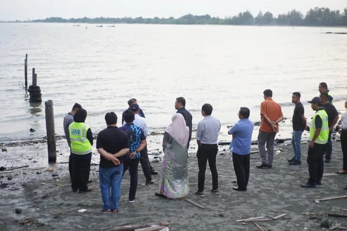 Malaysian authorities inspecting the area affected by the oil spill on June 19, in Pengerang. 