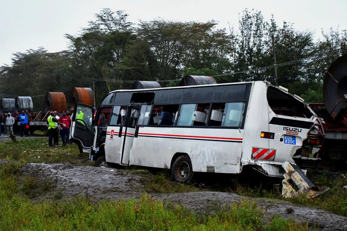 People gather in front of the wreckage of a staff bus that collided at a railway crossing, in Naivasha, Kenya, August 7, 2025. REUTERS/Stringer