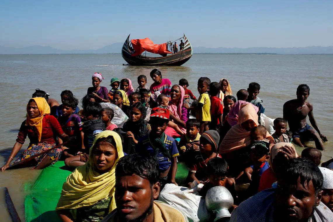 Rohingya refugees on a makeshift boat are questioned by officials in Bangladesh after crossing from Myanmar.