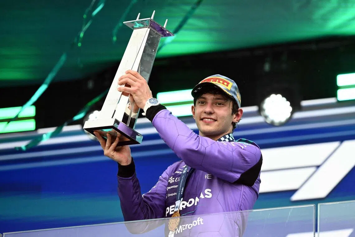Mercedes' Italian driver Kimi Antonelli holds the trophy as he celebrates on the podium after the 2026 Miami Formula One Grand Prix.