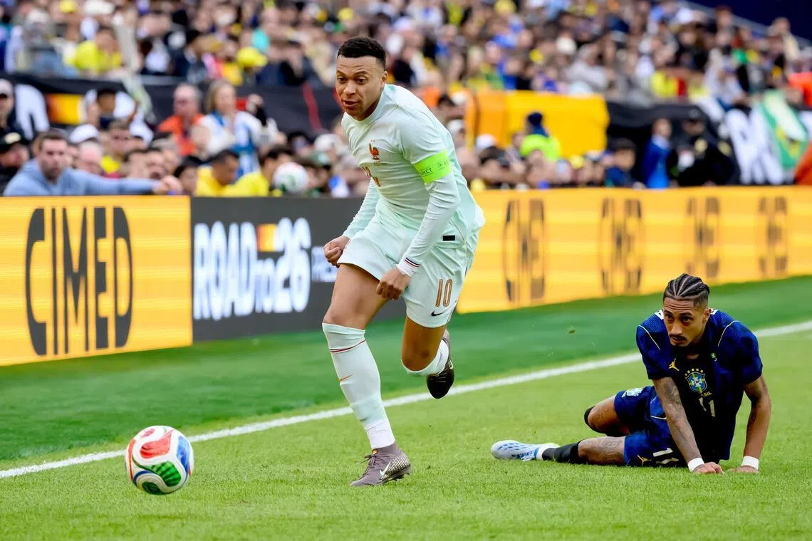 France's Kylian Mbappe surging clear of Brazil's Raphinha during their friendly on March 26.