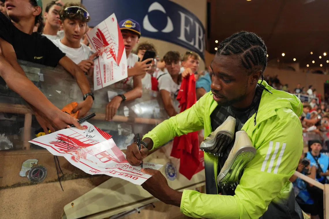 Noah Lyles signs autographs for fans following his 200m win in Monaco.