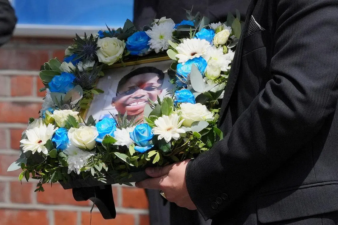 FILE PHOTO: A funeral director carries a floral tribute inset with a photograph of Daniel Anjorin, 14, following his funeral service at Jubilee Church in Ilford, east London, Britain, following his funeral service. Picture date: Friday May 17, 2024.   Jonathan Brady/Pool via REUTERS/ File Photo