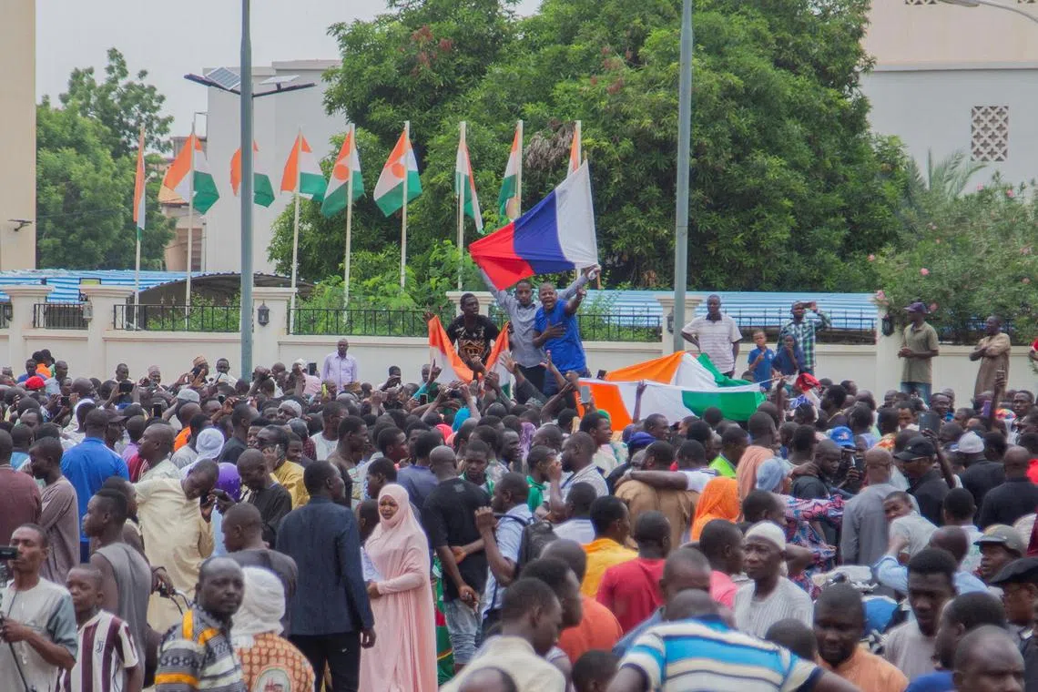 Hundreds of supporters of the coup gather and hold a Russian flag in front of the National Assembly, in the capital Niamey.