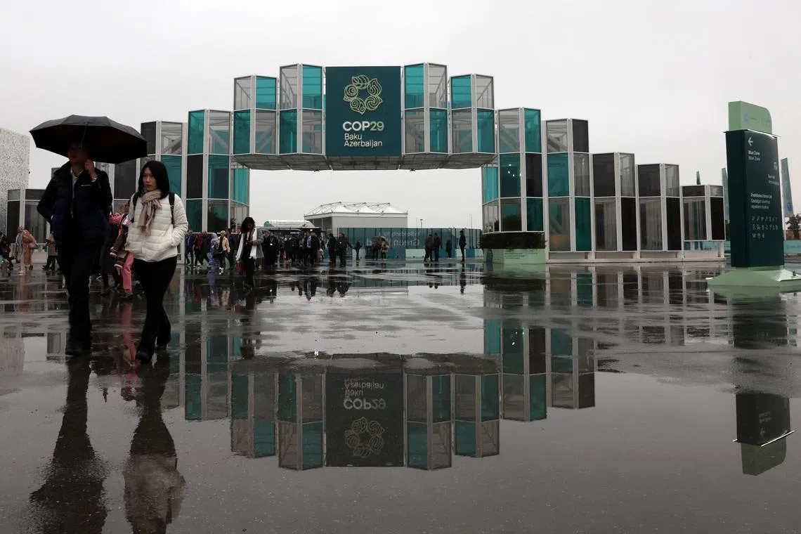 People walk at the entrance of the venue of the United Nations climate change conference COP29, in Baku, Azerbaijan November 18, 2024. REUTERS/Murad Sezer/File Photo