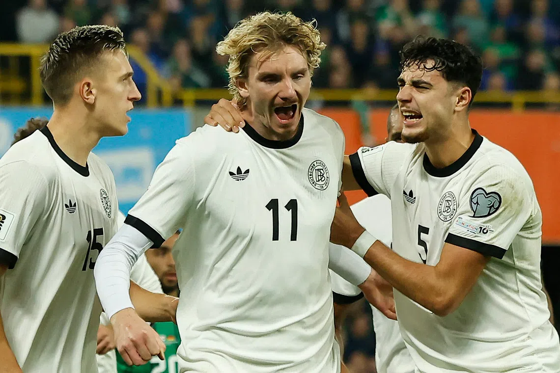 Soccer Football - FIFA World Cup - UEFA Qualifiers - Group A - Northern Ireland v Germany - Windsor Park, Belfast, Northern Ireland - October 13, 2025 Germany's Nick Woltemade celebrates scoring their first goal with Aleksandar Pavlovic REUTERS/Clodagh Kilcoyne