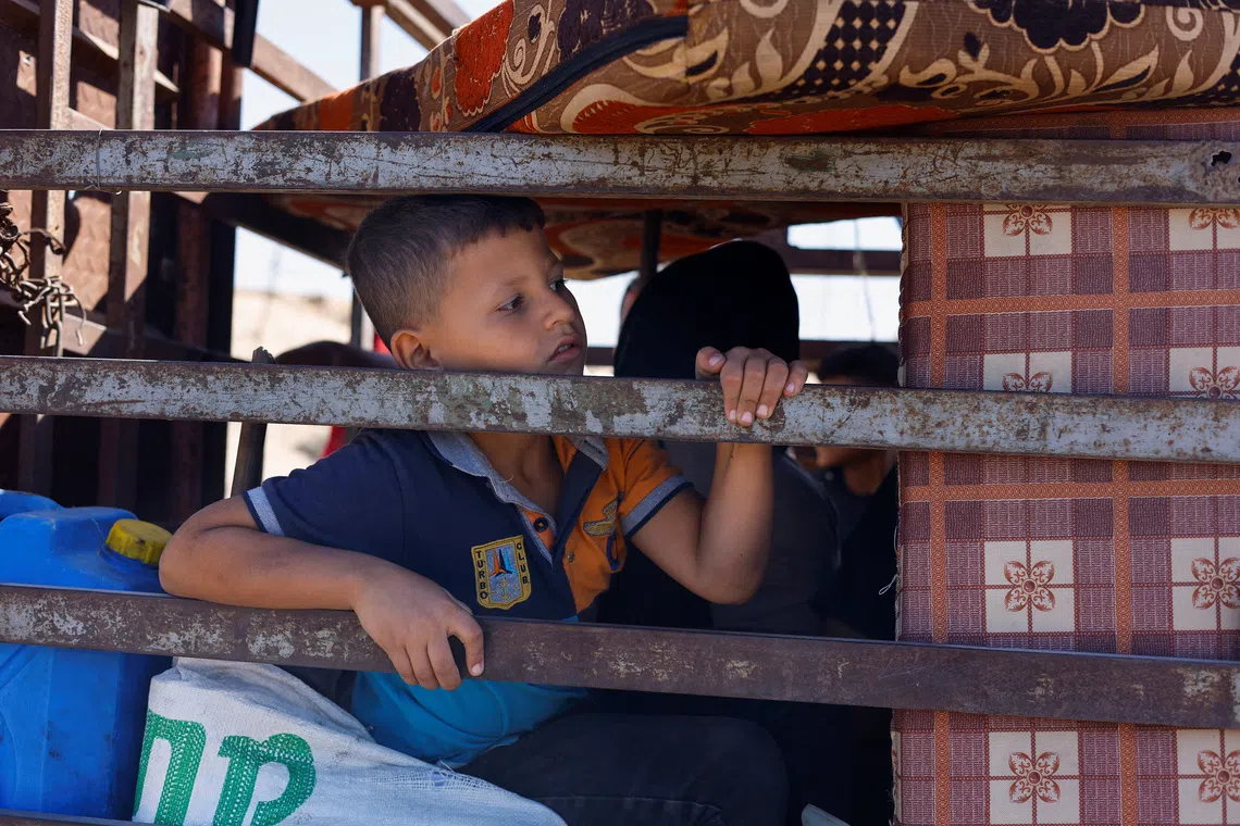 A child, part of crowds of displaced Palestinians fleeing northern Gaza due to an Israeli military operation, rides southward in a vehicle packed with personal belongings, after Israeli forces ordered residents of Gaza City to evacuate to the south, in the central Gaza Strip, September 21, 2025. REUTERS/Mahmoud Issa