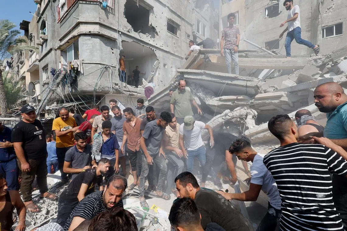 Palestinians gather at the site of an Israeli strike on a house in Khan Younis, in the southern Gaza Strip, on Oct 24.
