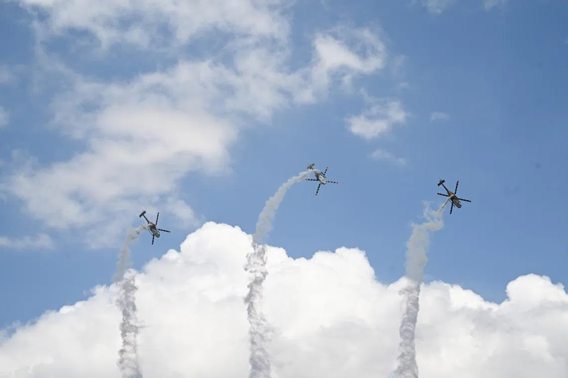 The Indian Air Force's Sarang Aerobatic Team performing in their HAL Dhruv helicopters during an aerial flying display on the first day of the Singapore Airshow at Changi Exhibition Centre in Singapore, 20 Feb 2024.