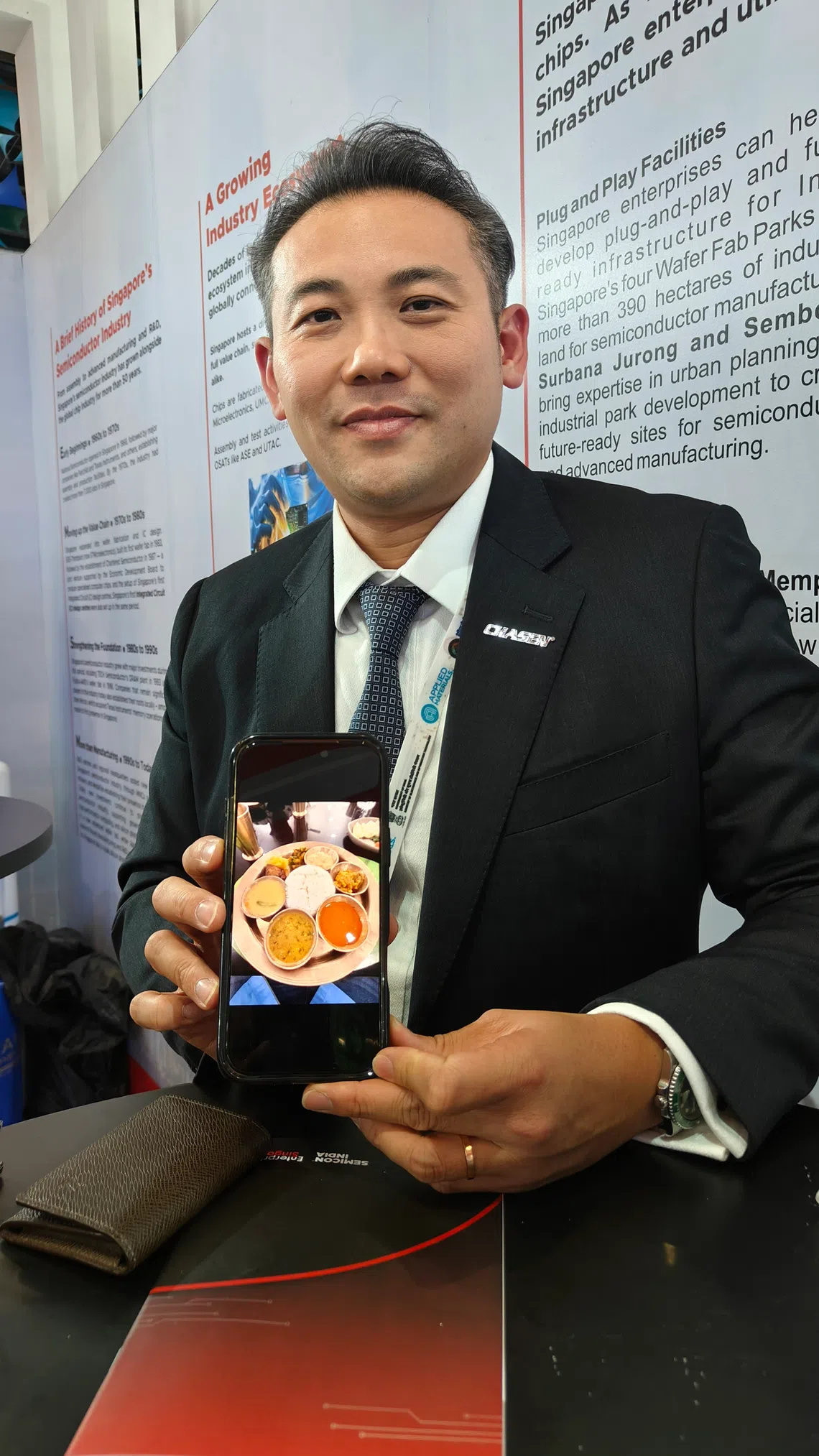 Alvin Lau, country manager for Chasen (India) Hi-Tech Logistics Services, at SEMICON India 2026. He is showing a pork thali meal he enjoyed at a restaurant in Assam, one of the Indian states that has attracted attention from semiconductor firms.