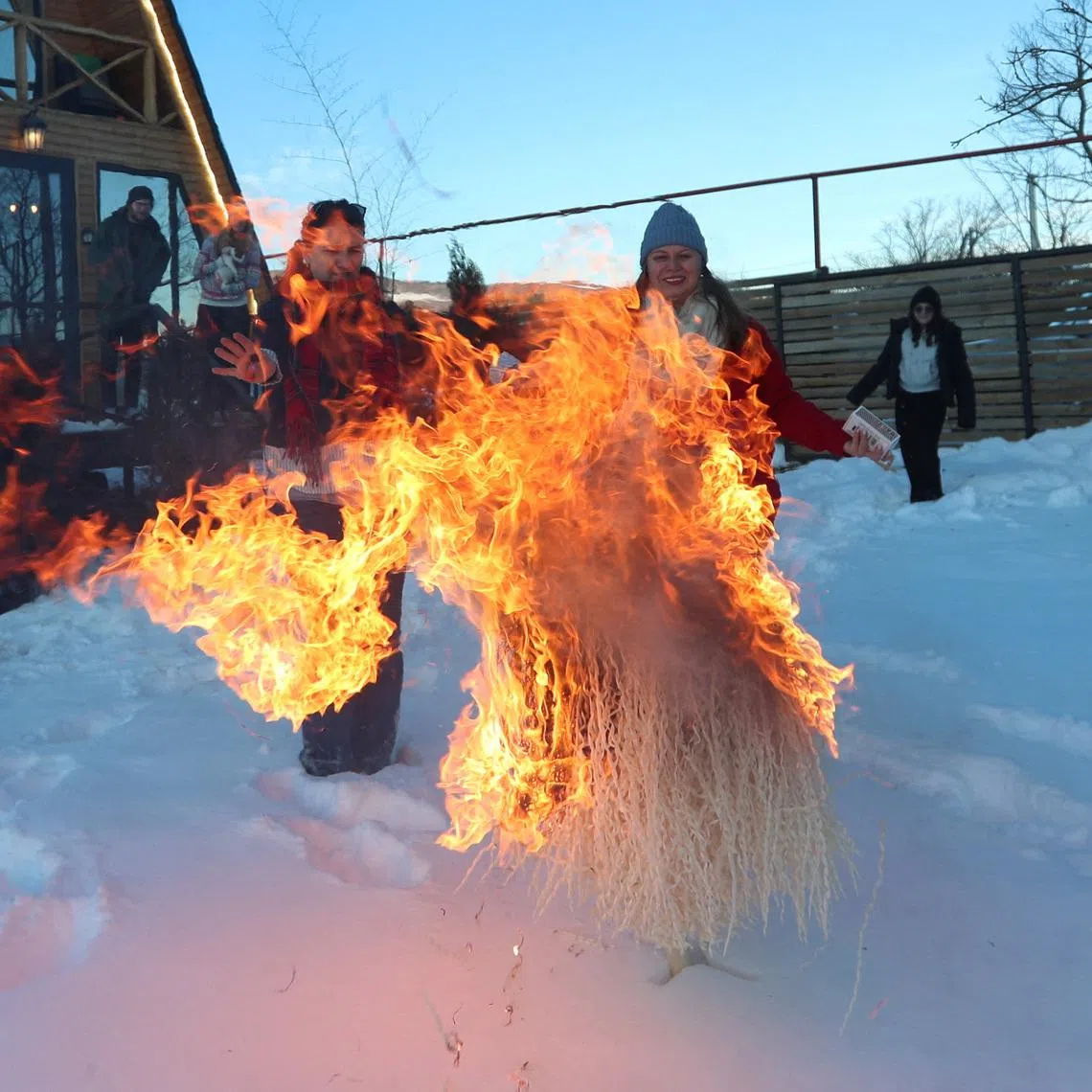 People watch the burning of chichilaki - a traditional Georgian Christmas tree made from dried walnut branches, during a celebration in the village of Tezeri, Georgia, January 3, 2026. REUTERS/Irakli Gedenidze