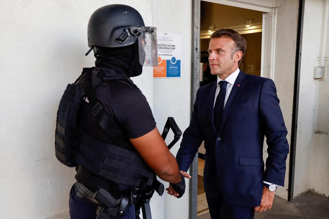FILE PHOTO: French President Emmanuel Macron shakes hands with a policeman upon his arrival at the central police station in Noumea, France's Pacific territory of New Caledonia on May 23, 2024. LUDOVIC MARIN/Pool via REUTERS/File Photo