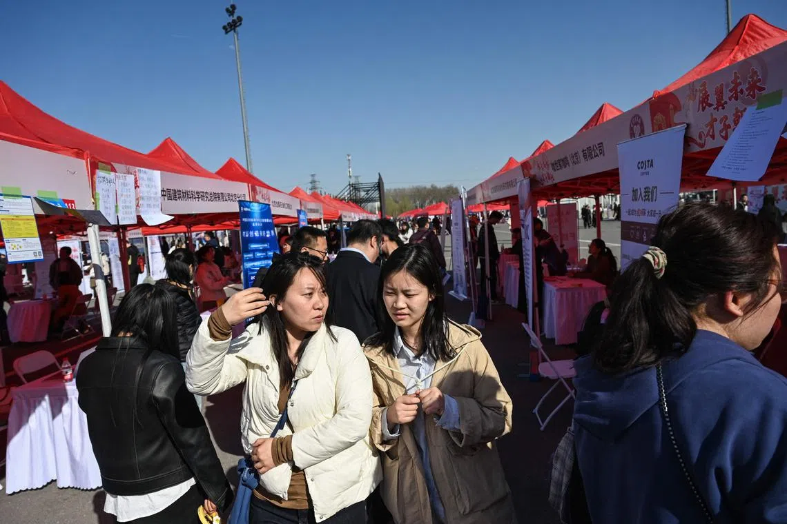 Job seekers attend an employment fair in Beijing. Almost two-thirds of the global digital economy will be powered by the United States and China. 