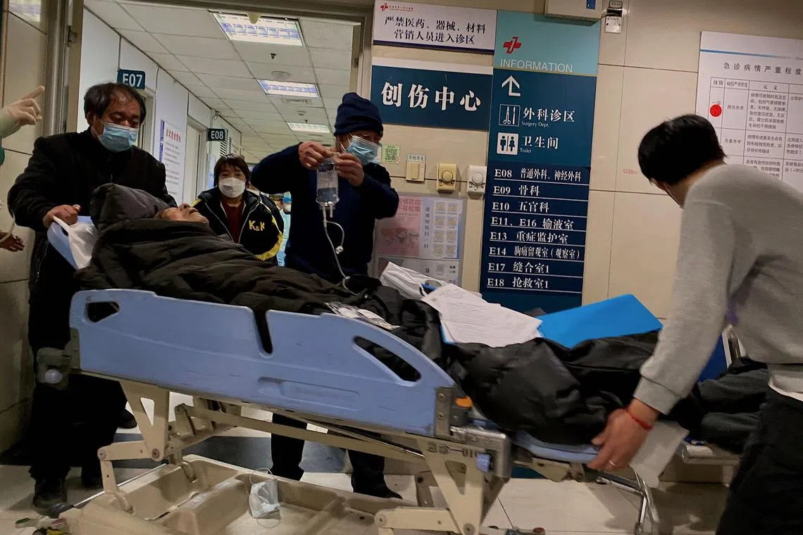 This picture shows people moving a Covid-19 patient on a gurney at Tianjin First Center Hospital in Tianjin on December 28, 2022. - Cities across China have struggled with surging infections, a resulting shortage of pharmaceuticals and overflowing hospital wards and crematoriums after Beijing suddenly dismantled its zero-Covid lockdown and testing regime. (Photo by Noel Celis / AFP)