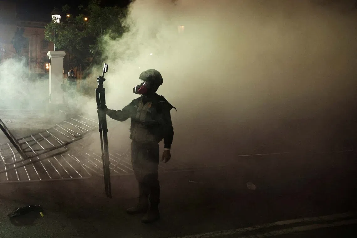 A member of the media recording the action while standing amidst tear gas during a demonstration organised by a youth collective called "Generation Z" to express discontent over a controversial pension reform plan, as well as the government of Peru's President Dina Boluarte, whose approval ratings have plummeted due to ongoing scandals and rising crime, in Lima, Peru, Sept 28, 2025. 