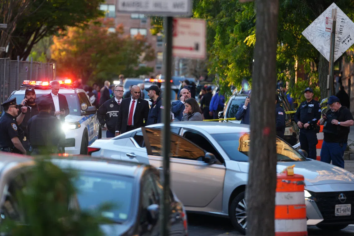 Members of law enforcement gather near a vehicle at the scene of a shooting reportedly involving ICE agents in the Bronx borough of New York City, on Oct 8.