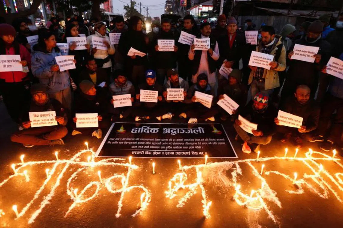FILE PHOTO: People hold placards as they take part in a condolence and protest meeting following the plane crash of a Yeti Airlines operated aircraft, in Pokhara on January 15, 2023, in Kathmandu, Nepal January 16, 2023. REUTERS/Navesh Chitrakar/File Photo