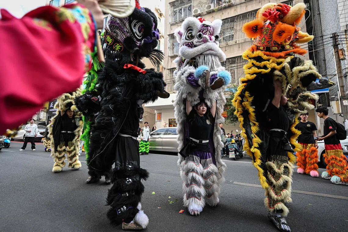 Sporting furry sequinned trousers and a black training top, Ms Lin Xinmeng (second from right) flings her male teammate into the air.