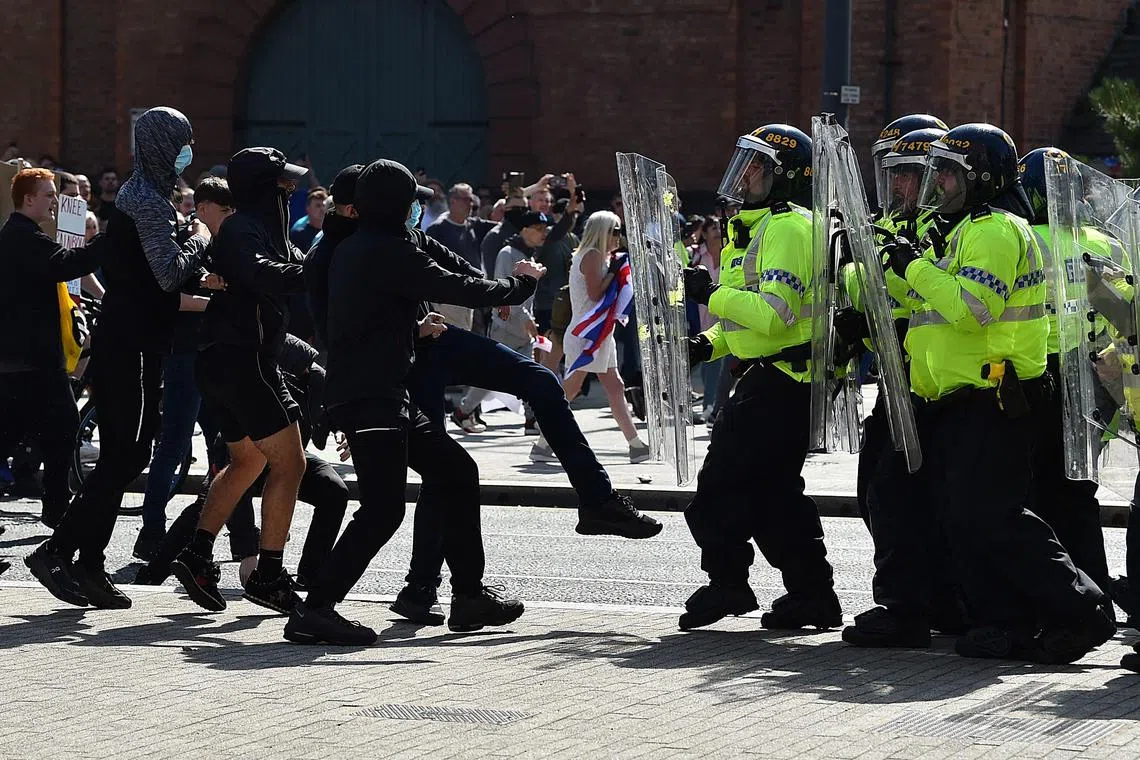 Police officers face protesters outside the Liver Building in Liverpool on Aug 3, 2024 during the "Enough is Enough" demonstration held in reaction to the fatal stabbings in Southport.