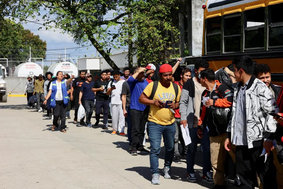 FILE PHOTO: Honduran migrants deported from the United States wait in line to board a bus at the Center for Attention to Returned Migrants, in San Pedro Sula, Honduras January 30, 2025. REUTERS/Yoseph Amaya/File Photo