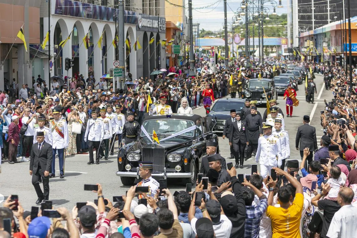 The crowd taking photos of royal couple Prince Abdul Mateen and his bride Anisha Rosnah during the street procession of the royal wedding ceremony in Bandar Seri Begawan, Brunei, on Jan 14, 2024. 