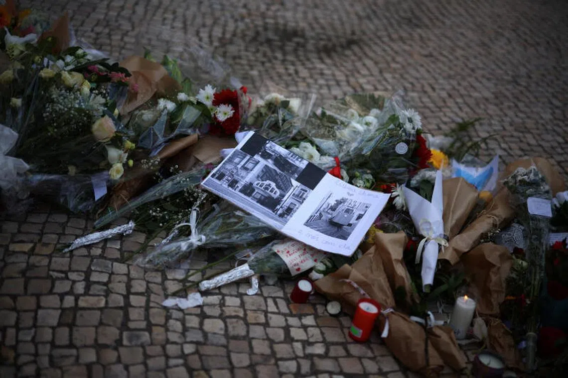 Old pictures of the Gloria funicular railway car, accompanied by a text reading: "Lisbon cries and we cry with her," placed at a makeshift memorial in Lisbon.