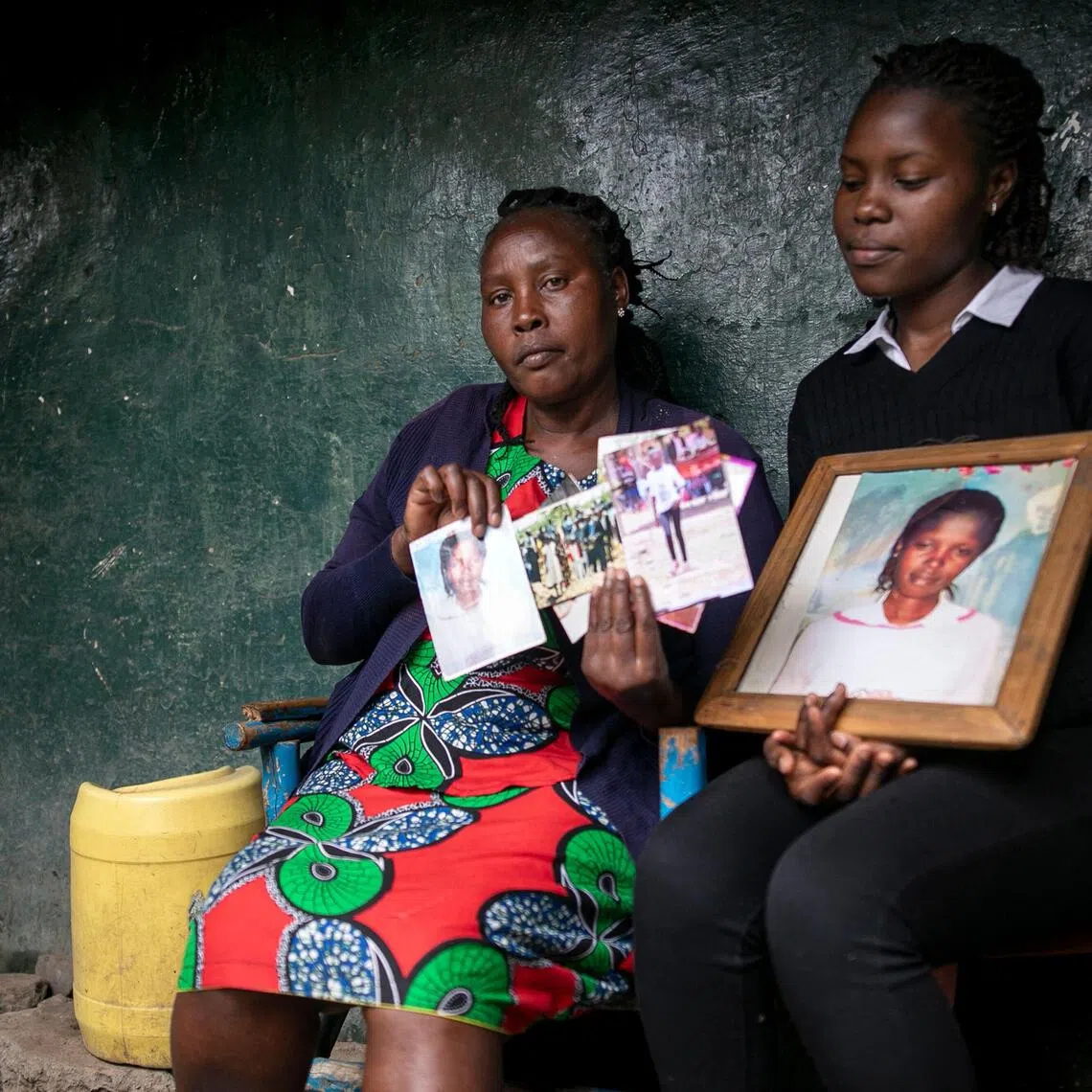 Ms Rose Wanjiru (left) holds a photo of her sister, Agnes, who was allegedly murdered by a British soldier in March 2012.
