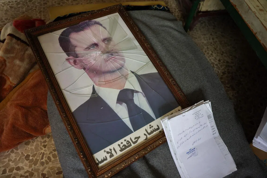 A portrait of Syrian President Bashar al-Assad is pictured with its frame broken, in a Syrian regime's Political Security Branch facility on the outskirts of the central city of Hama, following the capture of the area by anti-government forces, on Dec 7. 