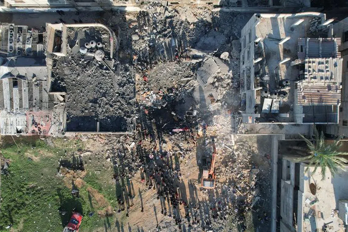 Palestinians gather at the site of an Israeli strike on a house, as the conflict between Israel and the Palestinian Islamist group Hamas continues, in Rafah in the southern Gaza Strip, December 19, 2023. REUTERS/Shadi Tabatibi/File Photo