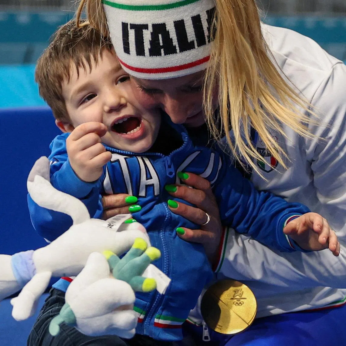 Gold medallist Francesca Lollobrigida of Italy celebrates her victory in the women's 3000m speed skating event with her son Tommaso in Milan, Italy, February 7, 2026. REUTERS/Piroschka Van De Wouw