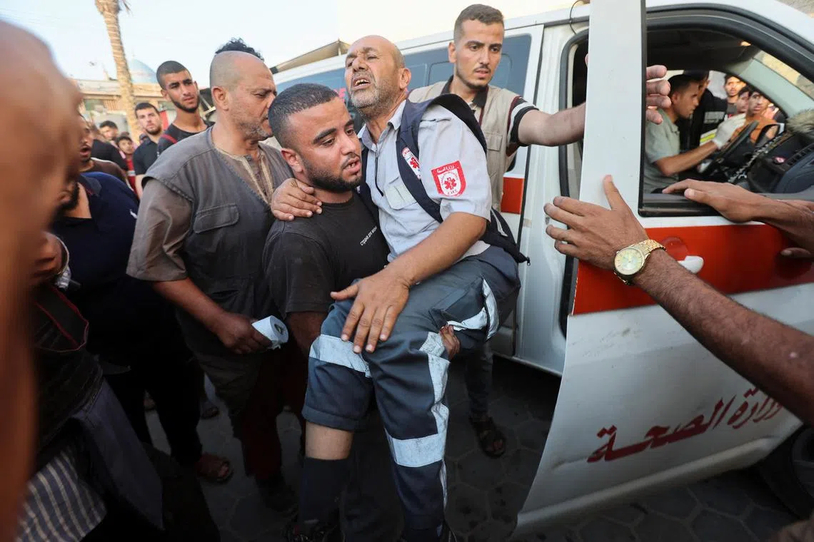 A man carries a paramedic - wounded in an Israeli strike - Deir-al-Balah, in central Gaza.