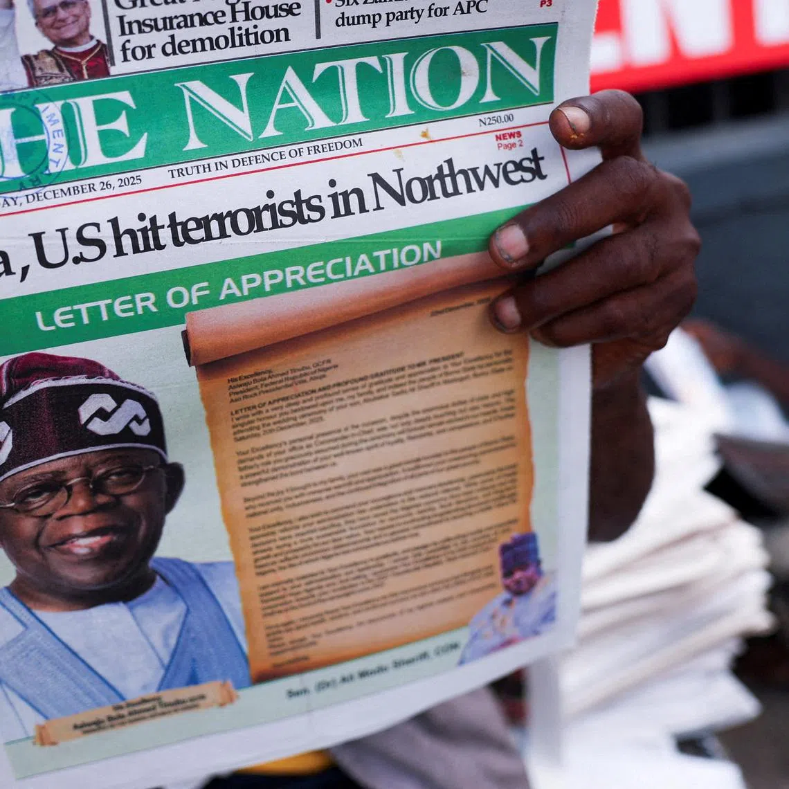 FILE PHOTO: People read newspapers reporting on U.S. airstrikes against Islamic State militants in Nigeria, according to U.S. President Donald Trump and the U.S. military, in Lagos, Nigeria, December 26, 2025. REUTERS/Sodiq Adelakun/File Photo