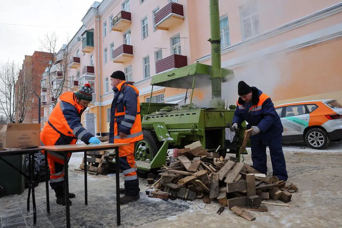 Specialists gather near a mobile kitchen deployed for citizens, after dozens of residential buildings were left without central heating due to a housing service accident caused by a cold snap in the town of Klimovsk in the Moscow region, Russia, January 9, 2024. REUTERS/Evgenia Novozhenina