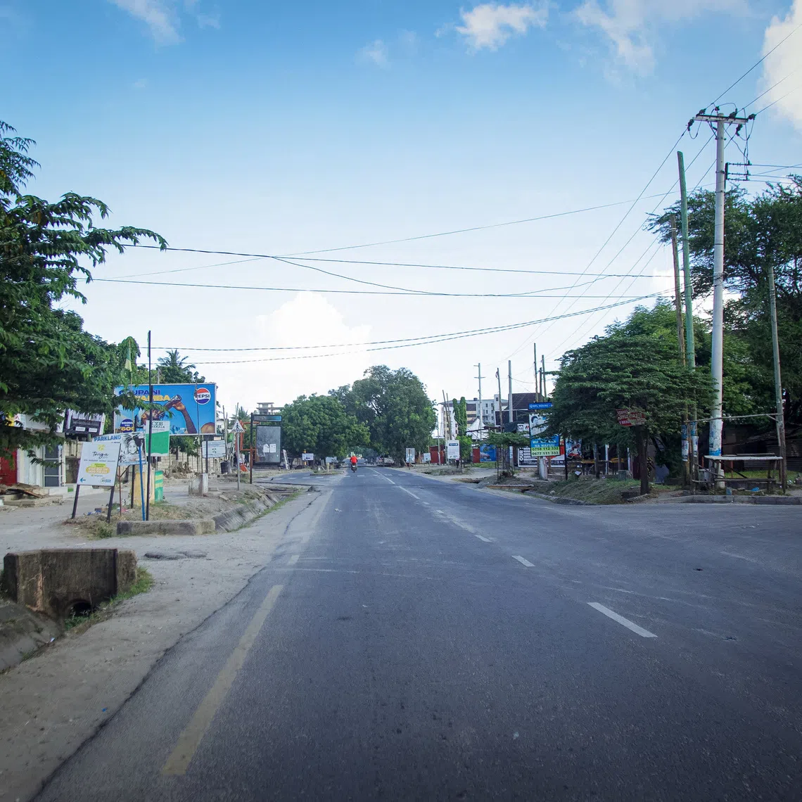 A motorcyclist rides on a deserted street during the 64th Independence Day under a silent lockdown imposed by the government to counter planned anti-government protests against deadly violence during demonstrations around the October elections, in Dar es Salaam, Tanzania, December 9, 2025. REUTERS/Emmanuel Herman