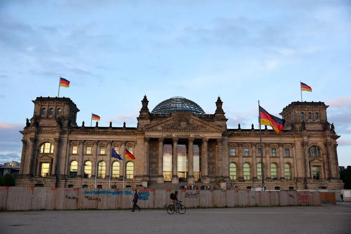 FILE PHOTO: Flags flutter outside the Reichstag building, the seat of the German parliament, the Bundestag, in Berlin, Germany May 6, 2025. REUTERS/Fabrizio Bensch/ File Photo