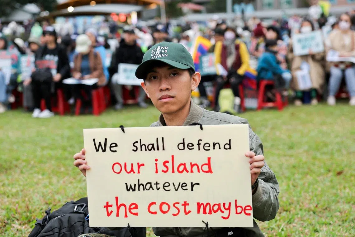 FILE PHOTO: A man poses with his own placard at a \"Stand up as Taiwan\" rally in Taipei, Taiwan December 8, 2024 REUTERS/Ann Wang/File Photo
