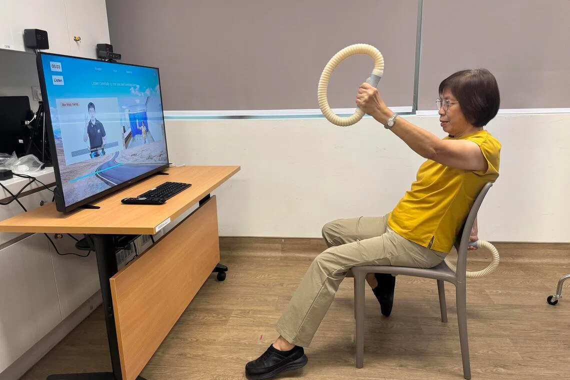 A woman attending a brain gym session takes part in interactive, gesture-driven gameplay using fitness apparatus.